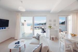 a living room with a white couch and a table at Barbas House in Kassiopi