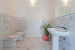 a white bathroom with a toilet and a sink at Luxury Apartments in Villa Cardinal Ciceri by Rent All Como in San Fermo della Battaglia +72 photos