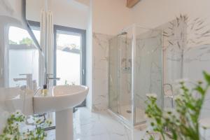 a white bathroom with a sink and a shower at Luxury Apartments in Villa Cardinal Ciceri by Rent All Como in San Fermo della Battaglia