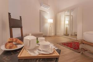 a living room with a table with cups and croissants at Luxury Apartments in Villa Cardinal Ciceri by Rent All Como in San Fermo della Battaglia