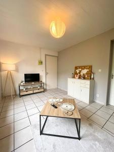 a living room with a table and a tv at L épicentre Gare d Amiens in Amiens