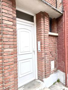 a white door on the side of a brick building at L épicentre Gare d Amiens in Amiens