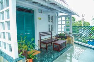 a porch with a bench and a blue door at The Berry House in Yercaud