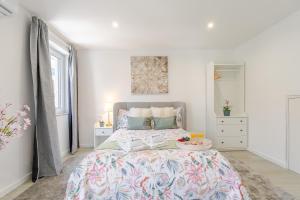 a bedroom with a large bed with a floral bedspread at HostWise - Modern & Bright Studio in Porto +27 photos