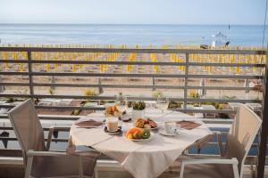 a table with a plate of food and a view of the beach at Hotel Las Vegas in Lido di Jesolo