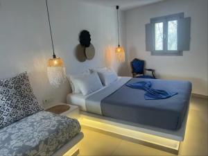 a bedroom with a bed and a chair in it at Rembelos Santorini in Perissa