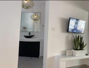a bathroom with a sink and a tv on a wall at Rembelos Santorini in Perissa +33 photos