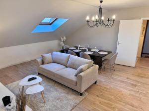 a living room with a couch and a dining table at Superbe appart sur la place in Cambrai