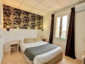 a bedroom with a bed and a wall mural at Hôtel de Flore in Saint-Raphaël