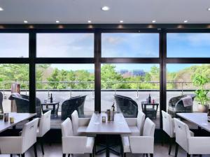 a restaurant with tables and chairs and large windows at Minamisenri Crystal Hotel - Vacation STAY 74035v in Suita