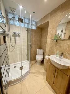 Salisbury Garden Apartment 3 beds 2 baths في Shrewton: حمام مع دش ومرحاض ومغسلة +9 صور
