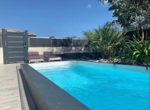 a swimming pool in a yard with a patio at Villa Madeleine - Piscine in Gujan-Mestras