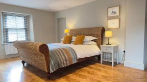 Salisbury Garden Apartment 3 beds 2 baths في Shrewton: غرفة نوم مع سرير مع اللوح الأمامي الخوص