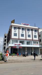 UmargāmHotel V Point的一座建筑,前面有一个人