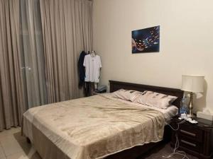 a bedroom with a bed and a table with a lamp at SoulSpace Stay in Ajman 