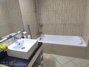 a bathroom with a white tub and a sink at SoulSpace Stay in Ajman 