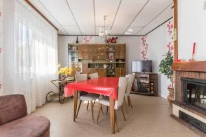ein Esszimmer mit einem roten Tisch und Stühlen in der Unterkunft Maison chaleureuse à Champagney avec vue sur la montagne in Champagney + 15 Fotos