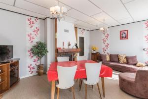 ein Wohnzimmer mit einem roten Tisch und weißen Stühlen in der Unterkunft Maison chaleureuse à Champagney avec vue sur la montagne in Champagney