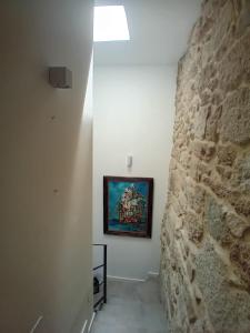 a hallway with a stone wall and a painting on the wall at Maravillosa casa con vistas al mar in Baiona