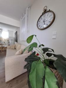 a living room with a couch and a clock on the wall at Mylo Casa Karfas in Chios