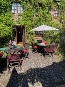 a patio with a table and chairs and an umbrella at The Coach House in Wareham