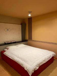a bedroom with a bed with white sheets at 佐渡ホテル Hotel NestTime in Sado