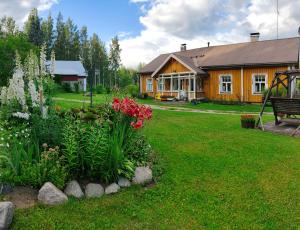 a house with a garden with flowers in the yard at Reittiö B&B in Sulkava