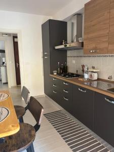 a kitchen with black cabinets and a table with chairs at Dimora la Tonnara in Porto San Giorgio