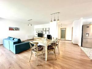 a living room with a table and a blue couch at Aky&Suki Sea View Apartments in Olimp