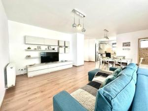 a living room with a blue couch and a kitchen at Aky&Suki Sea View Apartments in Olimp