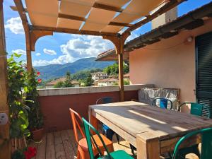 un tavolo in legno e sedie su un patio con vista di La terrazza sul Tetto a San Marcello Pistoiese
