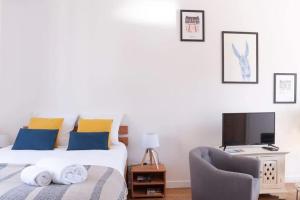 1 dormitorio con 1 cama, 1 silla y TV en Le Saint-étienne studio moderne et lumineux, en Rennes