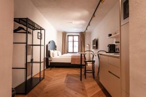 ein Zimmer mit einer Küche und ein Schlafzimmer mit einem Bett in der Unterkunft H5 Grauer Bär Studios & More in Innsbruck