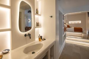 a bathroom with a sink and a mirror at SEAMENTO suites in Tinos +96 photos