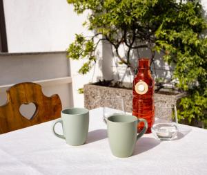 a table with two cups and a bottle of water at Apartma Frigidum in Vipava