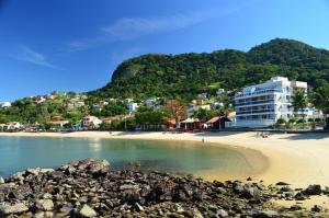 a view of a beach with a building in the background at Casa Cordelia Mangaratiba Centro in Mangaratiba