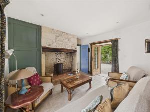 a living room with a couch and a fireplace at Piscine et domaine arboré partagés - maison pour 4 in Montignac