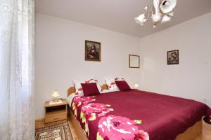 a bedroom with a bed with a red comforter at Apartman Gordana in Pula
