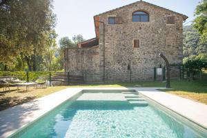 an outdoor swimming pool in front of a stone building at L'Altell in Montagut