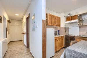 a kitchen with wooden cabinets and a white refrigerator at Apartman Gordana in Pula