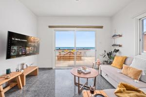 a living room with a couch and a view of the ocean at Lagoon Blue Beach House by Nomads in Kato Yialia