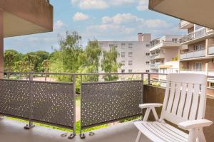 a balcony with a white chair and a view at Appartement proche Disneyland & Paris - 20 minutes - proche gare RER in Noisiel