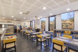 a dining room with tables and chairs and windows at Appart'hôtel Odalys City - Lyon Centre Confluence in Lyon +70 photos