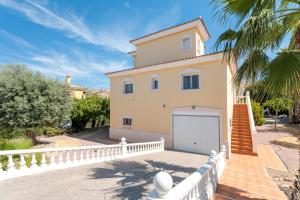 a house with a white fence and a garage at Chalet Limonita in Mutxamel