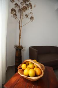 a bowl of lemons and oranges on a wooden table at Te Rrapi Rooms in Qeparoi i Sipërm