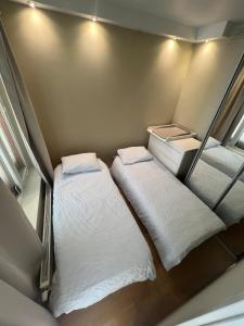 a small room with two beds in it at Spacious apartment with sea-view and sunset in Oslo