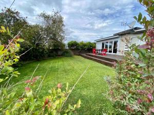 a yard with a house and a lawn with a yard at Lakeside reserve house close to city centre in Rotorua