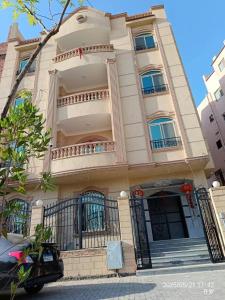 a white building with a balcony on a street at 北京之夜华人民宿餐厅 chinese hotel in Banī Ghālib