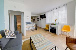 a living room with a couch and a table at Le Green, appartement rénové, 4 chambres et jardin in Saint-Jacques-de-la-Lande