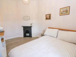 a bedroom with a bed and a fireplace at 3 Railway Cottages in Long Marton